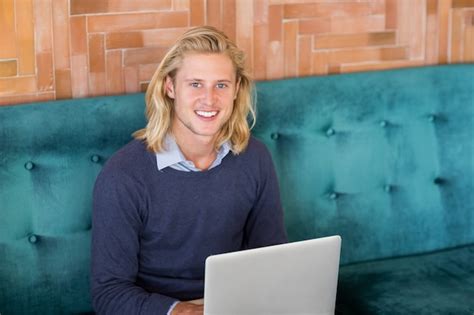 Premium Photo | Portrait of smiling man using laptop