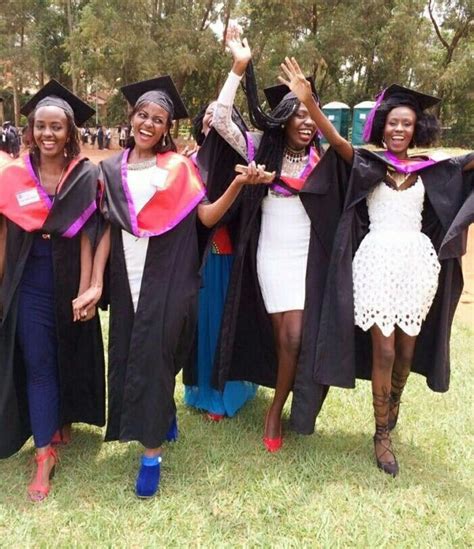 several women in graduation gowns and hats are posing for the camera with their hands up