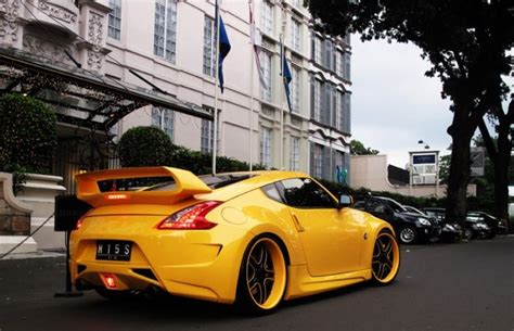 a yellow sports car parked in front of a building