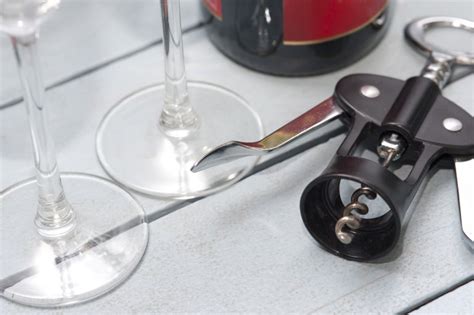 Corkscrew bottle opener alongside wineglasses - Free Stock Image