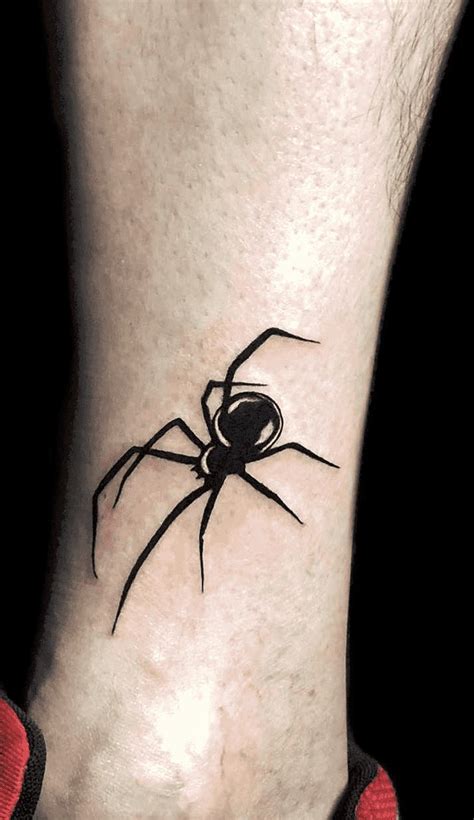 a small black spider tattoo on the ankle