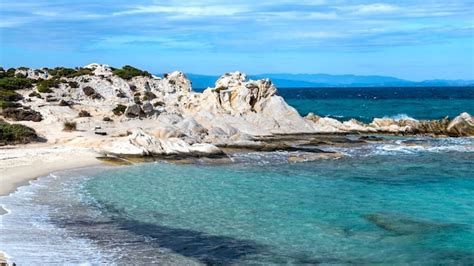 Costa do mar egeu com vegetação ao redor, rochas e arbustos, água azul com ondas, grécia | Foto ...