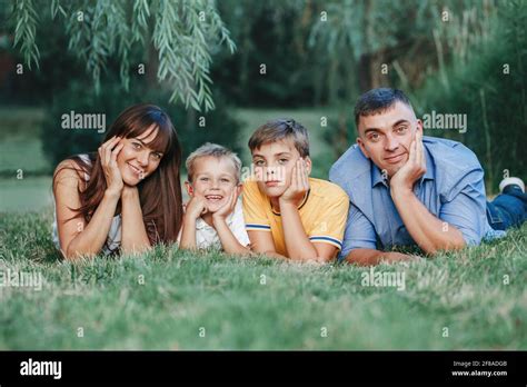 Beautiful happy Caucasian family of four people lying on a ground in ...