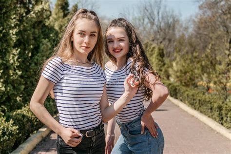 Two Smiling Young Female Girl Friends Having Fun in Park. Two Teen Student Young Woman in Jeans ...