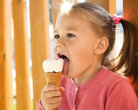 Download - Cute little girl is eating ice-cream outdoors — Stock Image