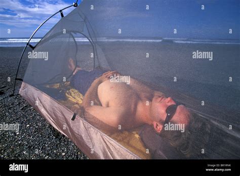 A man sleeping in his tent on the beach on the Nicoya Peninsula, Costa ...