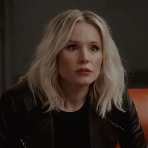 a woman with blonde hair sitting on a couch in front of a red leather chair