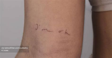 "I'm ok" lettering tattoo placed on the inner arm.