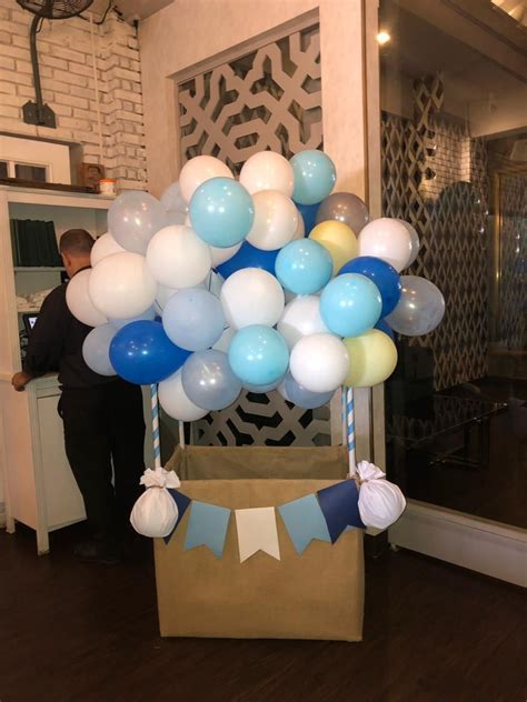 a bunch of balloons that are on top of a cardboard box in the middle of ...