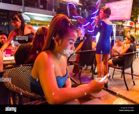 Nightlife, barmaid holding smartphone, clubs, Phnom Penh, Cambodia Stock Photo - Alamy