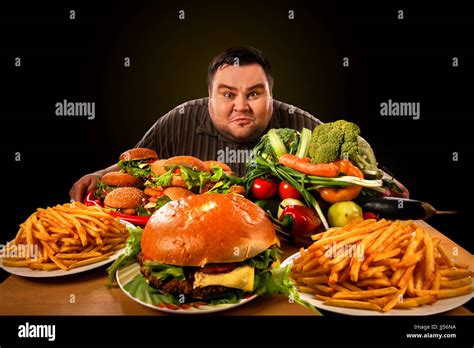 Diet fat man makes choice between healthy and unhealthy food Stock Photo: 148861814 - Alamy