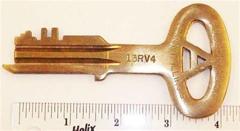 an old golden key with a ruler next to it