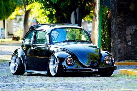 a black beetle parked on the side of a road