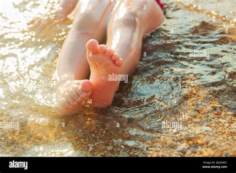 kids feet on the beach in the water Stock Photo - Alamy