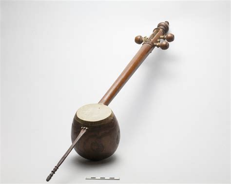 Muscial instrument (oriental lute, tar) with 3 strings and reddish wooden cocoanut-shaped ...