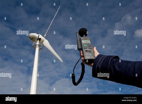 A sound level meter is held up to a wind turbine to measure the noise emitted in decibels Stock ...