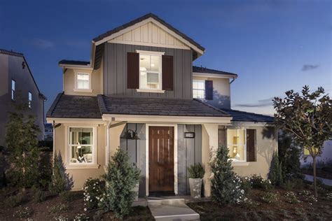 a house that is lit up at night with lights on the front and side windows