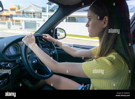 Teenager girl concentrating while driving car through city street Stock Photo - Alamy