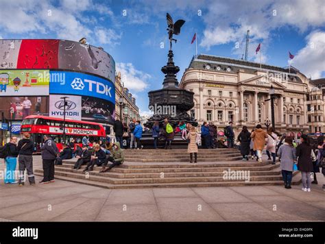 Piccadilly Circus, London, England, with the statue of Eros, crowds of tourists and a red London ...