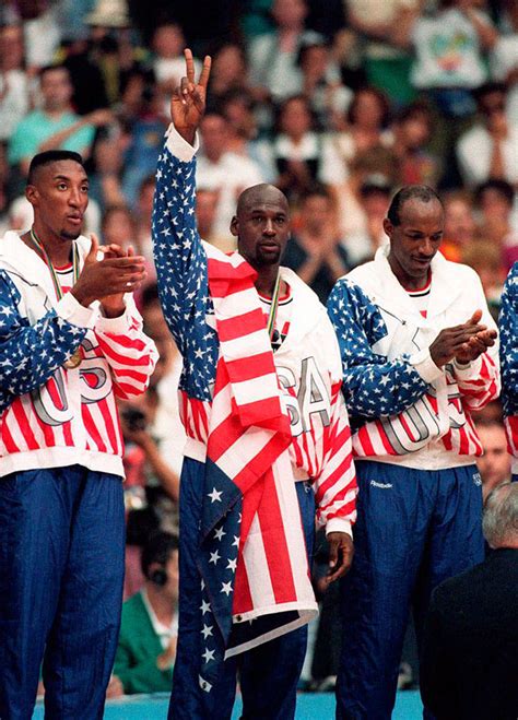 Raising his hand in recognition, Michael Jordan is awarded a gold medal ...