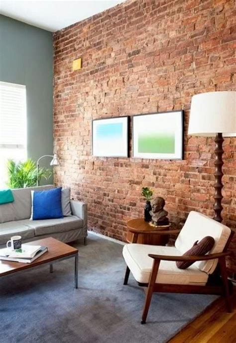 a living room filled with furniture and a brick wall