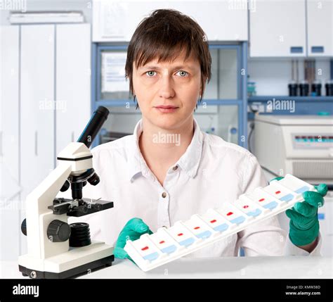 Histologist with a microscope and a tray of microscopic slides on a white background Stock Photo ...