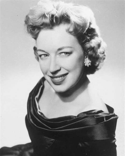 an old black and white photo of a woman in a dress smiling at the camera