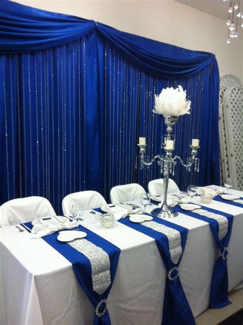 Head table with royal blue back drop and crystal step curtains | Royal blue wedding decorations ...