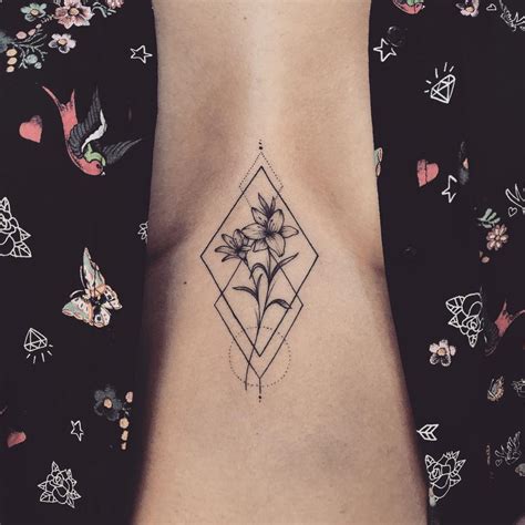 Flower in a rhombus tattoo on the sternum - Tattoogrid.net