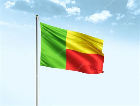 Premium Photo | Benin national flag waving in blue sky with clouds benin flag 3d illustration