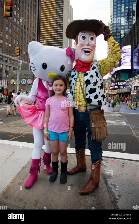 Hello Kitty and Toy Story Woody cartoon character costumes posing with children in Times Square ...