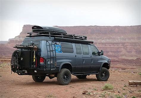 an suv parked on the side of a dirt road