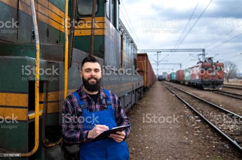 Portrait Of Engine Train Driver Standing By Locomotive At Train Station ...