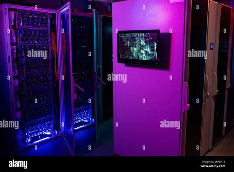Monitor hanging on server rack cabinet in data center in neon purple and blue colors, open ...