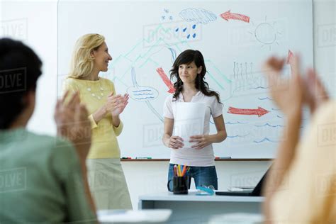 High school student finishing classroom presentation, classmates and teacher clapping - Stock ...