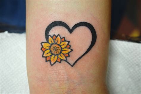 a tattoo with a sunflower on the side of it's arm that says, wrist ...