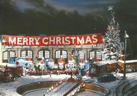 a train station with christmas decorations on the roof and trees in the snow at night