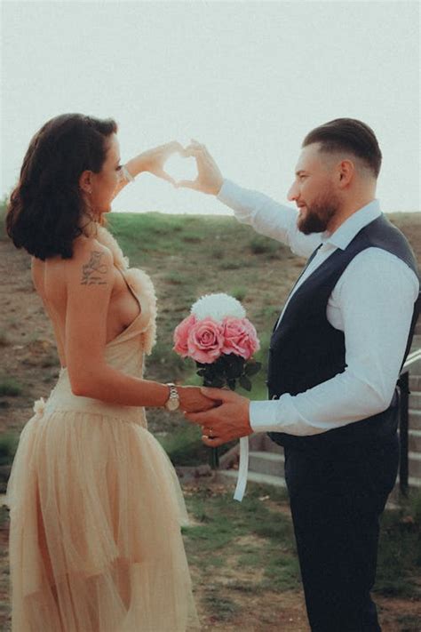 Couple doing a Heart-shaped Hand Gesture · Free Stock Photo