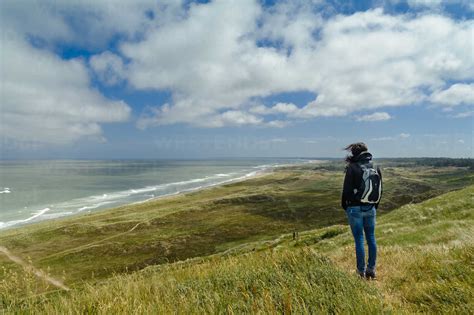 Denmark, Jutland, woman standing in dune landscape stock photo