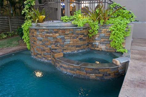 Lagoon pool with spa, bridge, and bar area by Lucas Lagoons Inc.