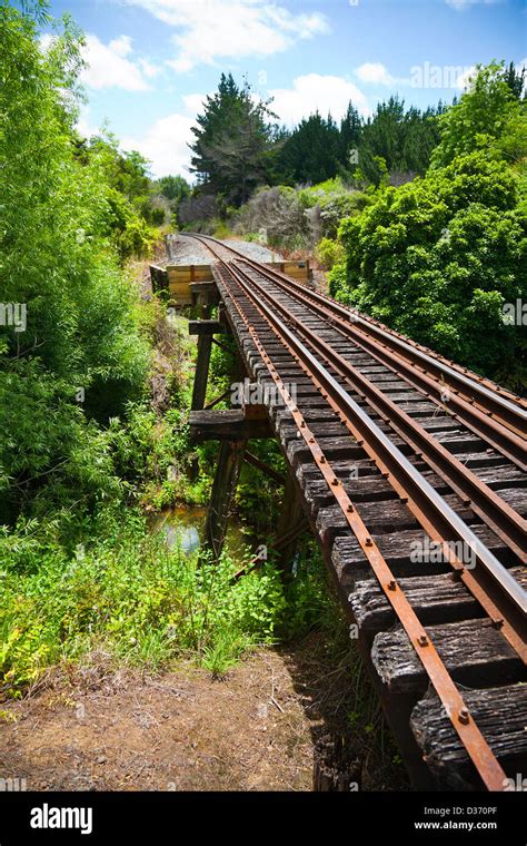 A view along a working railway track on an old trestle bridge over a ...