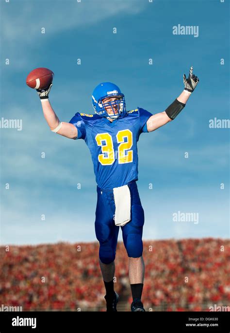 American footballer holding ball Stock Photo - Alamy