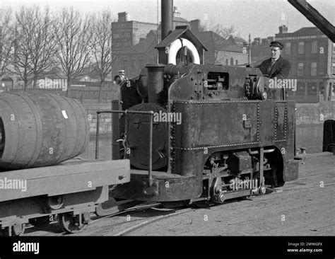 A man driving a tram engine to transport barrels Stock Photo - Alamy