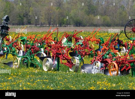 Colorfully painted antique plows on display at a farm near Corunna Michigan USA Stock Photo - Alamy