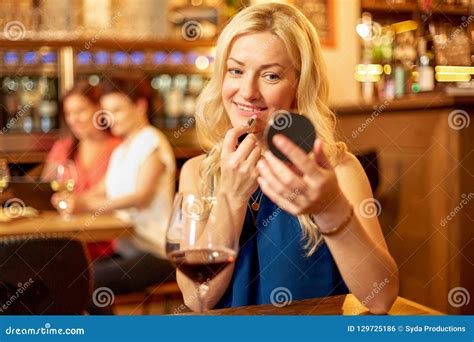 Woman with Lipstick Applying Makeup at Wine Bar Stock Photo - Image of beautiful, smiling: 129725186