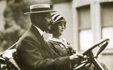 an old black and white photo of a man and woman driving a horse drawn ...