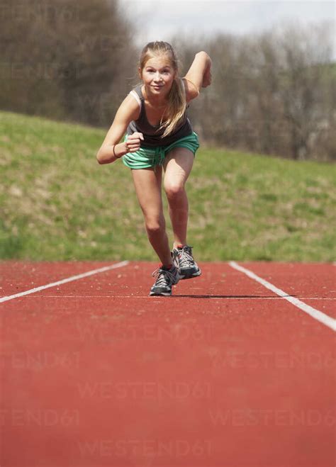 Austria, Teenage girl running on track, portrait stock photo