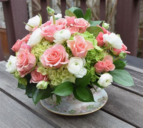 Floral tea cup with spray roses, ranunculus and hydrangeas. A neat flower arrangement… | Flower ...