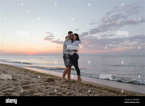 couple hugging look at sunset above sea Stock Photo - Alamy