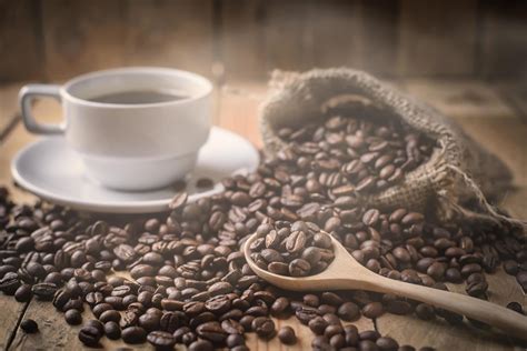 Coffee cup and beans on brown background 11550754 Stock Photo at Vecteezy